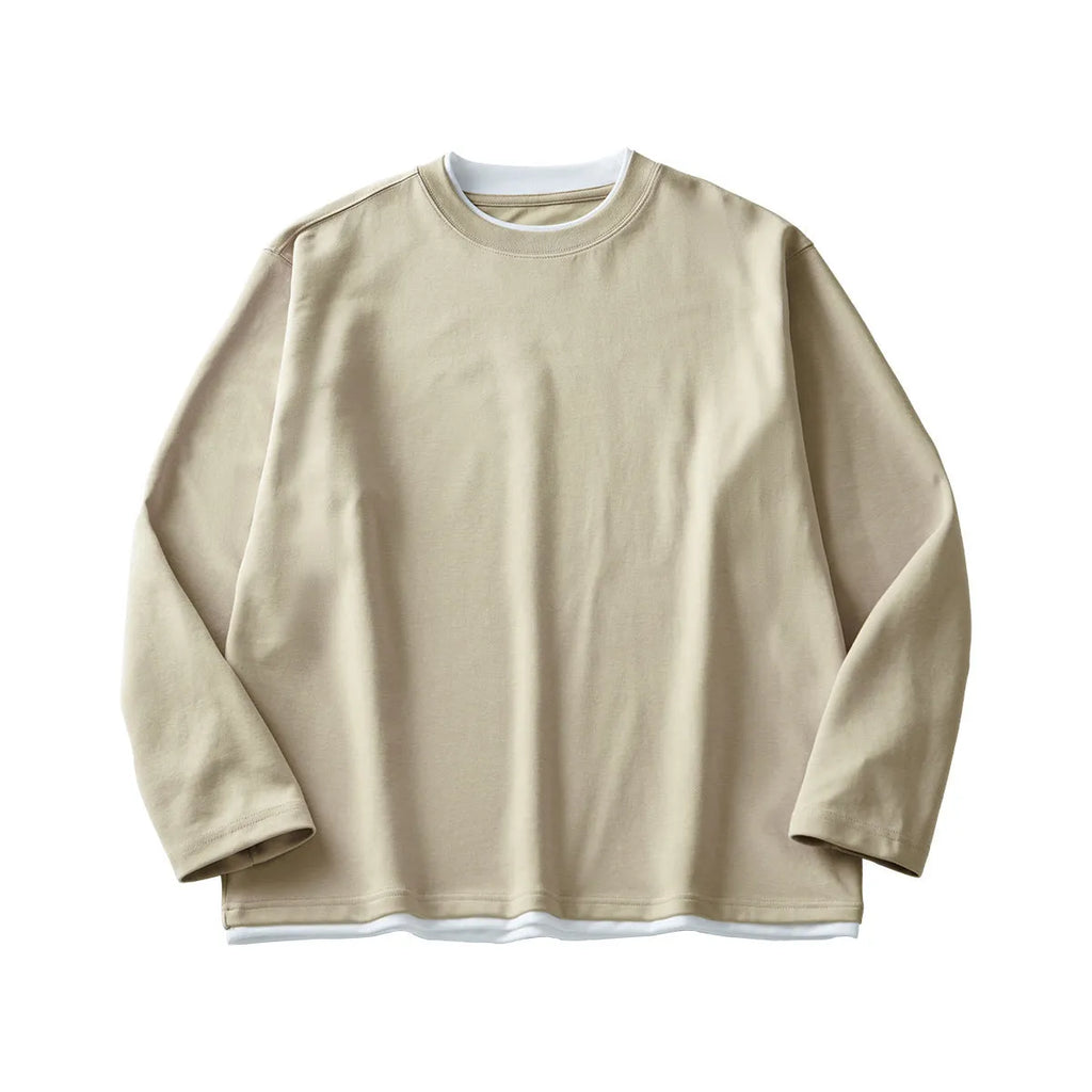 Man wearing a loose-fit long-sleeved cotton blend t-shirt in a solid colour, showing the round neck and casual style.