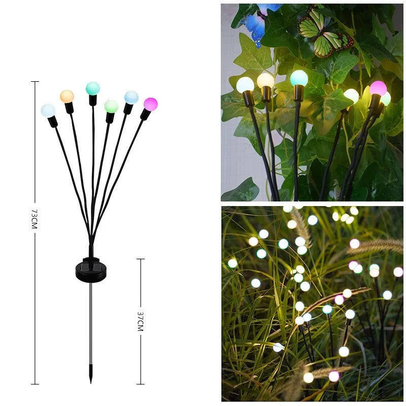 Solar-powered LED garden ground light with stainless steel spike, lit up in a lawn at dusk.