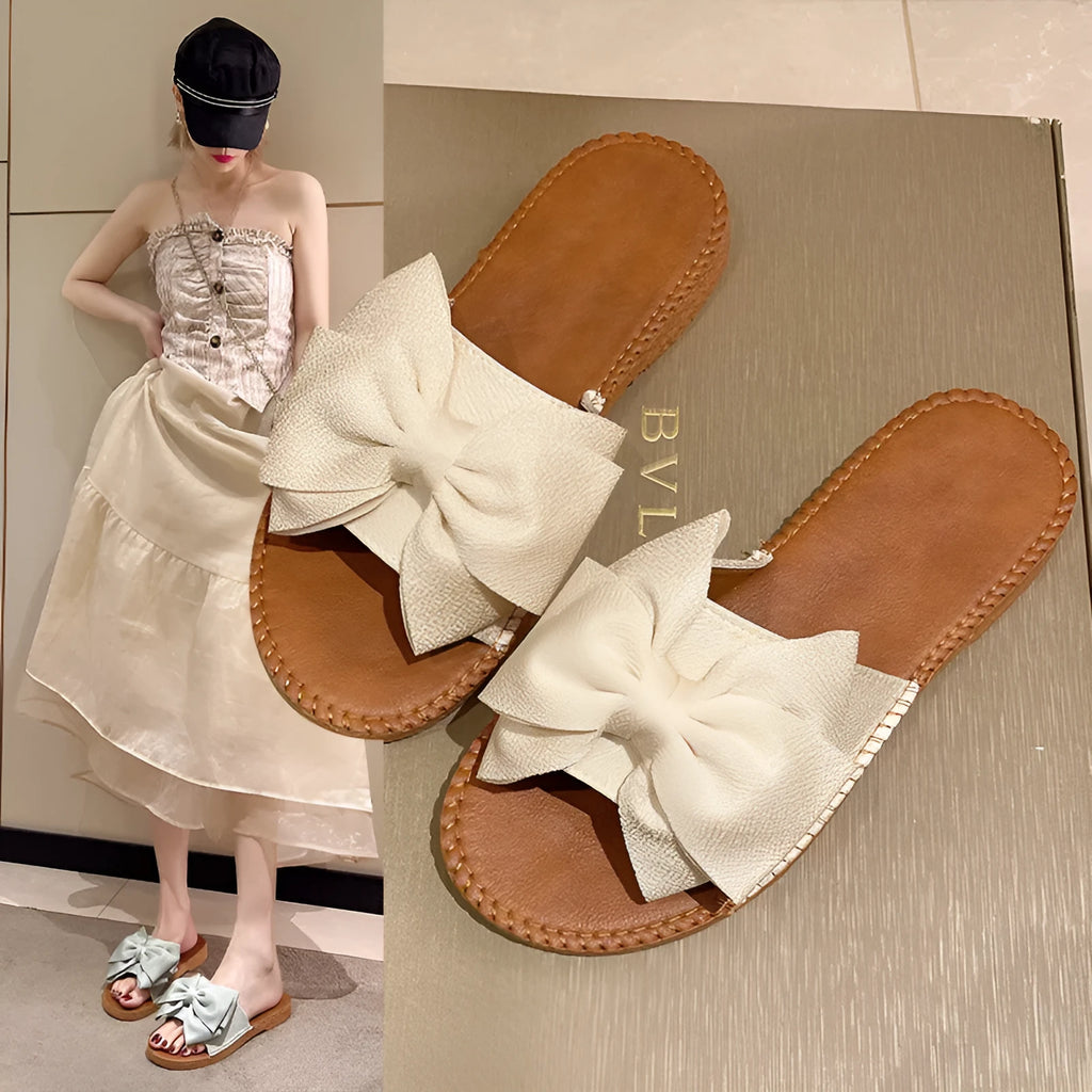 Women's beige suede slip-on sandals with a flat heel and soft bottom on a light background