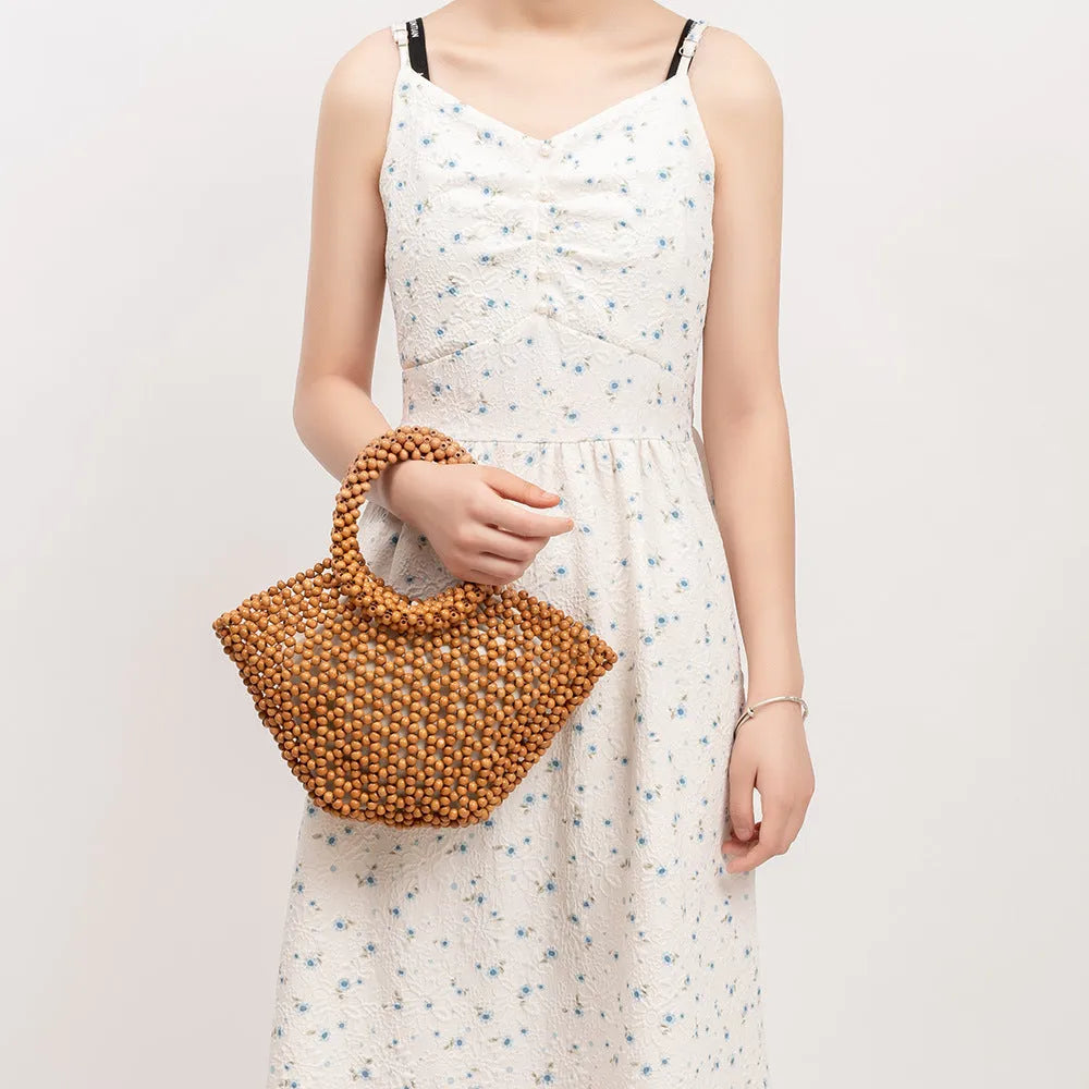 Hand-woven maple wood hollow handbag with wooden bead decoration in dumpling shape