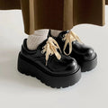 Matte black women's lace-up boots with a thick sole and a 6-8 cm heel.