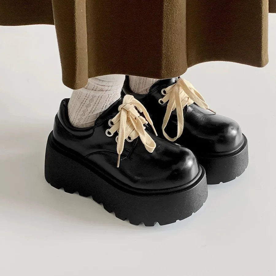Matte black women's chunky sole lace-up shoes with a round toe and buckle detail.
