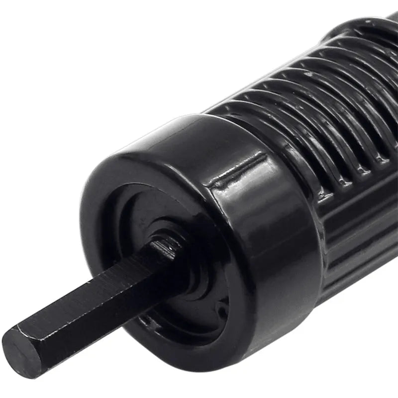Black metal electric drill rivet gun with handle, wrench, and rivet heads on a workbench.