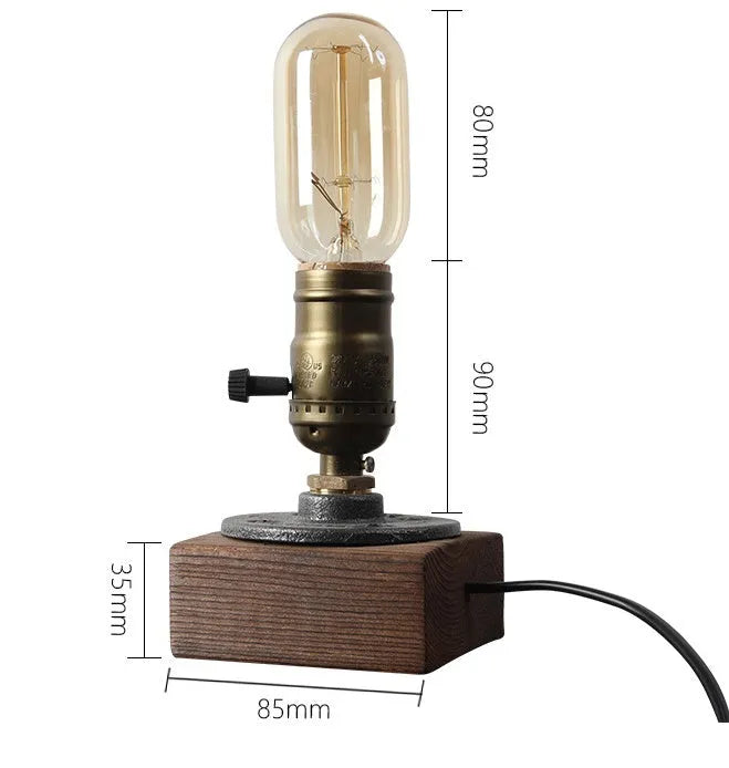 Small wooden and iron water pipe style table lamp on a surface.