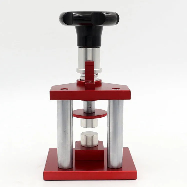 Watch repair spiral cap presser device with capsulator and set of 20 plastic moulds on a work surface.