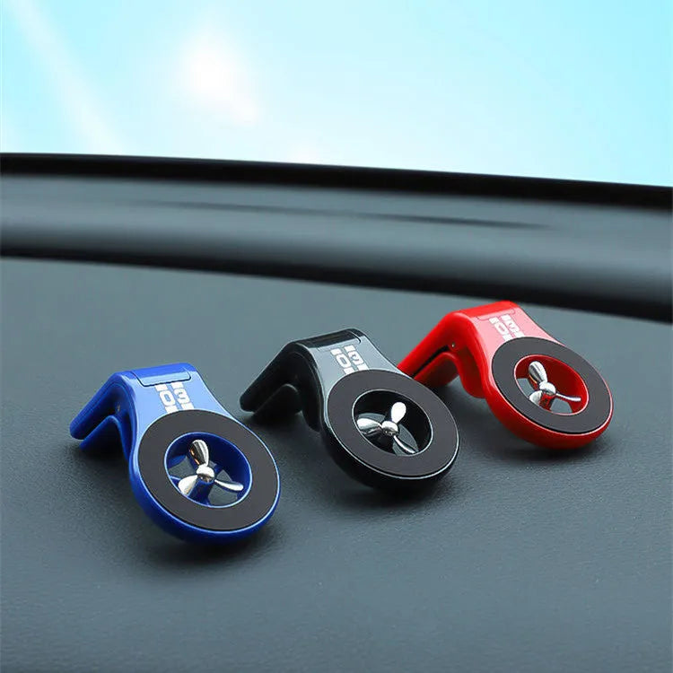 Black magnetic phone holder clipped onto a car air vent, showing phone attached and 360-degree rotation.