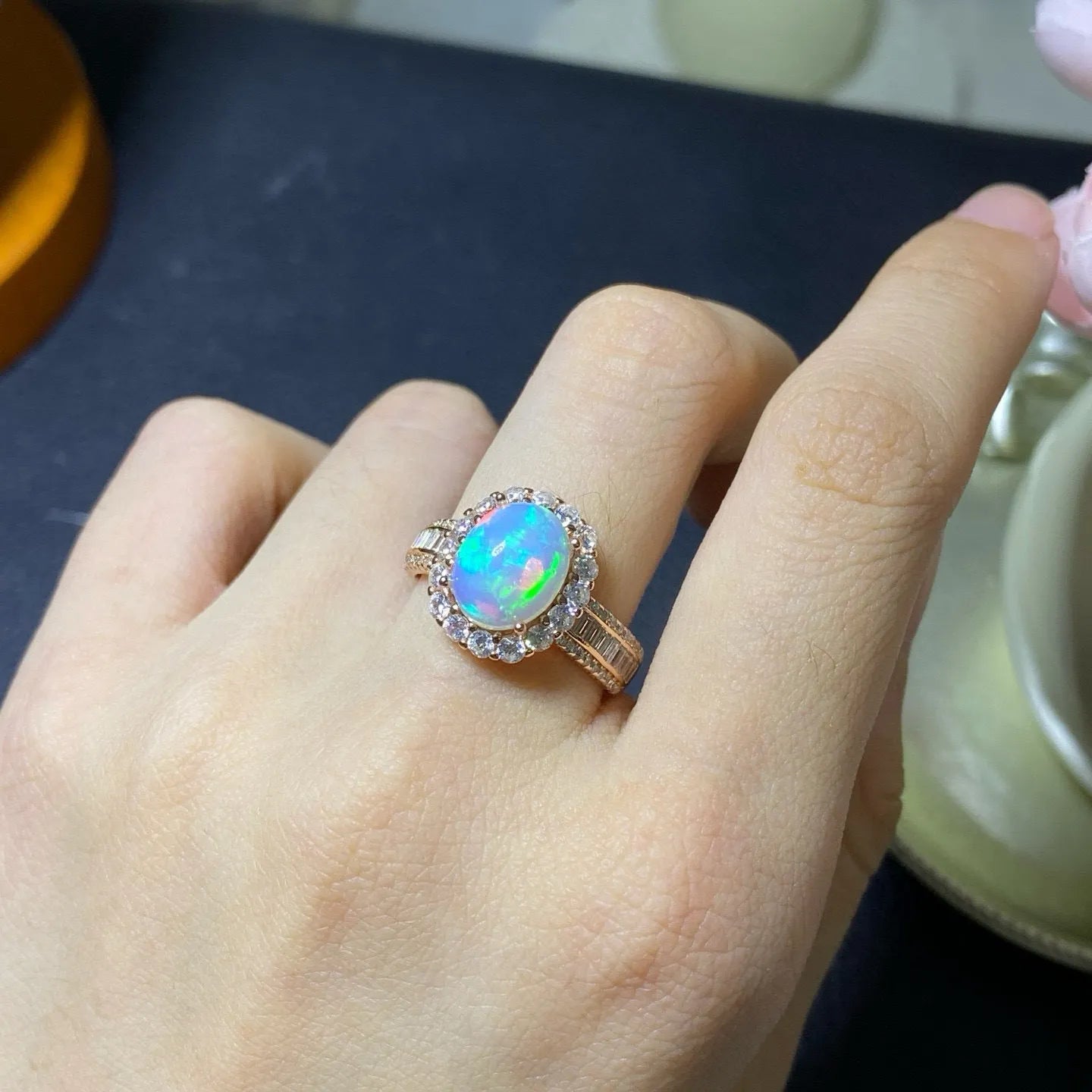 Handmade adjustable silver ring with a natural opal, shown in rose gold plating.
