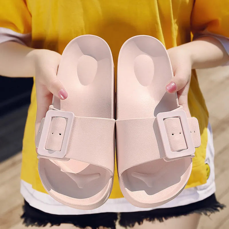 A pair of women's grey blue buckle slipper sandals with an adjustable strap on a soft EVA sole.