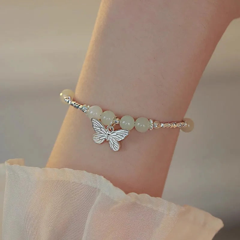 Women's copper butterfly jewellery set with electroplated silver finish, showing bracelet and necklace