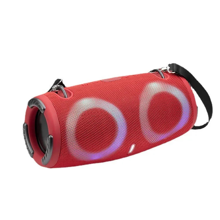 War Drum portable Bluetooth speaker with glowing RGB light ring in camouflage colour, sitting on grass.