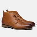 Men's brown Chelsea ankle boots with a visible side zipper on a wooden sole.