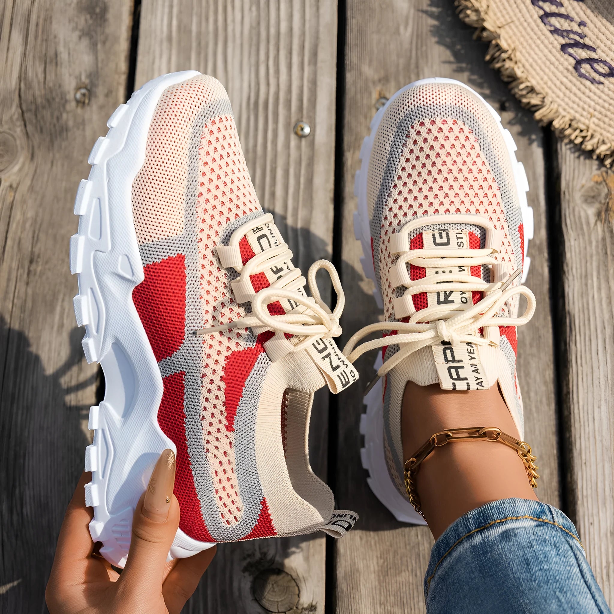 Women's Flyknit mesh lace-up sneakers in a grey colourway with a round toe and flat rubber sole.