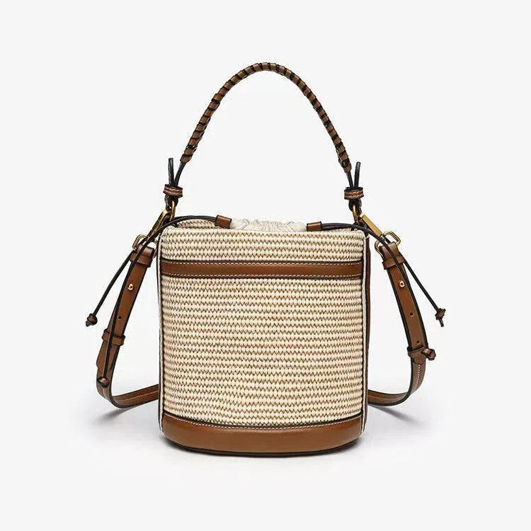 Brown PU cylindrical tote bag with dual handles, cross-body strap, and woven stitch detailing on a white background