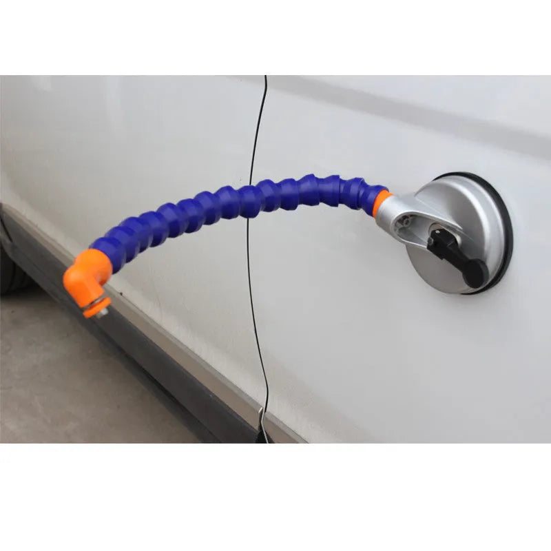 Blue car dent repair tool with suction cup and adjustable bracket on a metal car panel