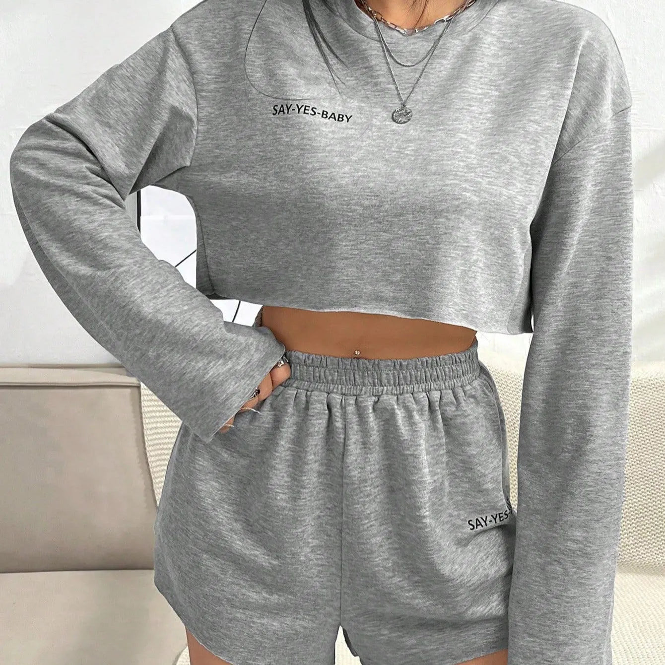 Grey women's long-sleeved t-shirt and short loungewear set laid flat showing both pieces