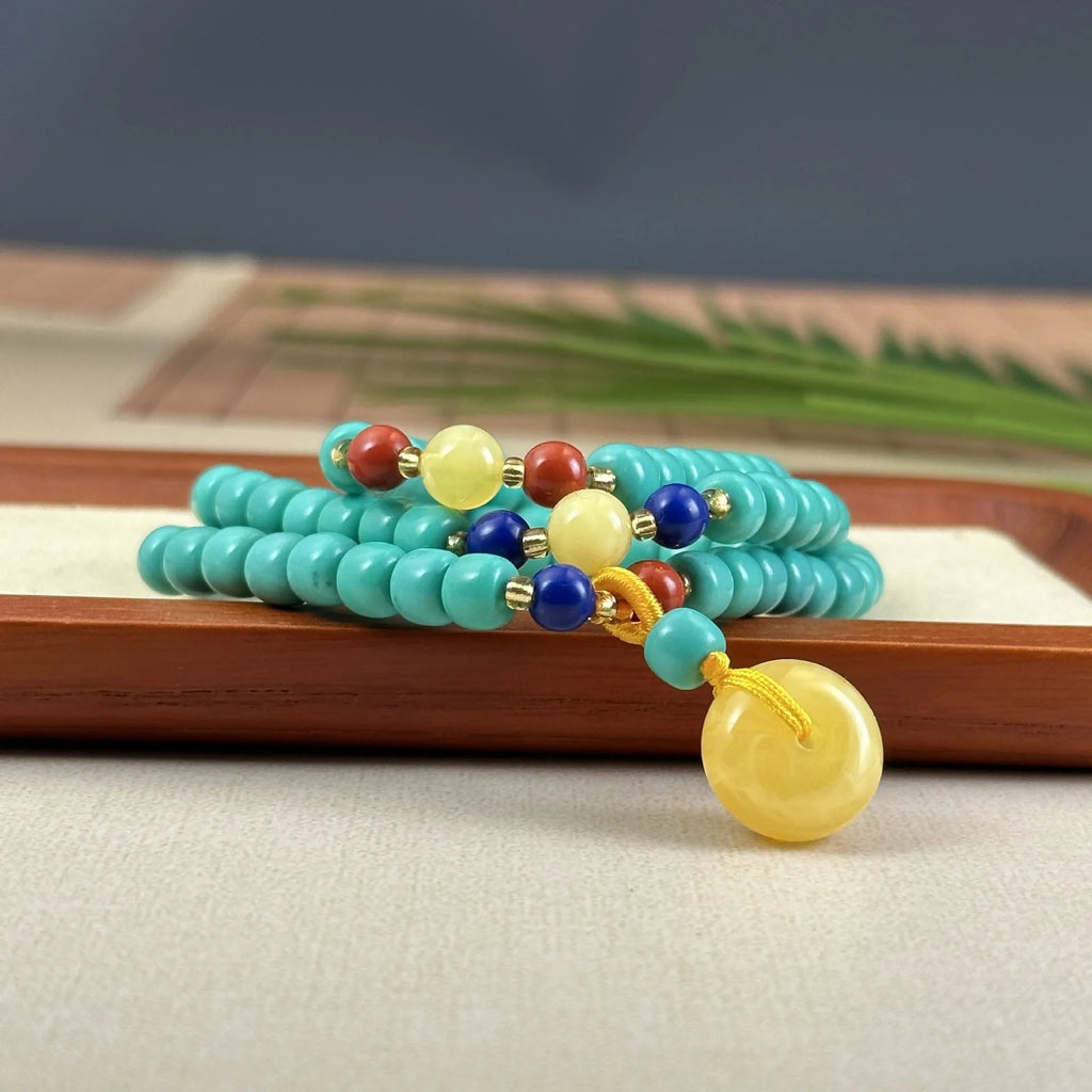 Close-up of a hand-woven mesh flower turquoise pendant on an adjustable ball bead necklace.