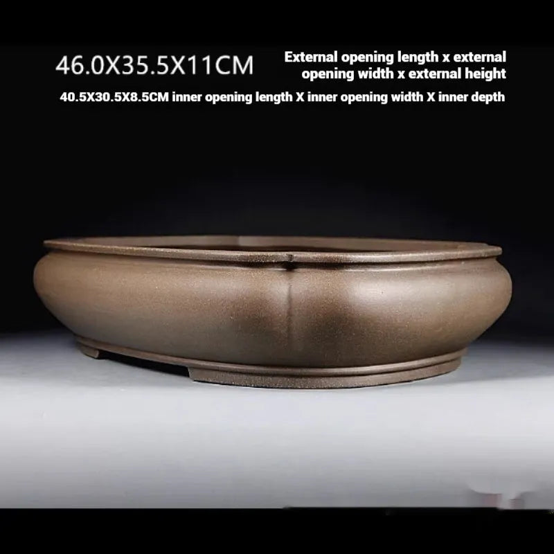Handmade antique papaya-shaped purple clay flower pot on a wooden surface.