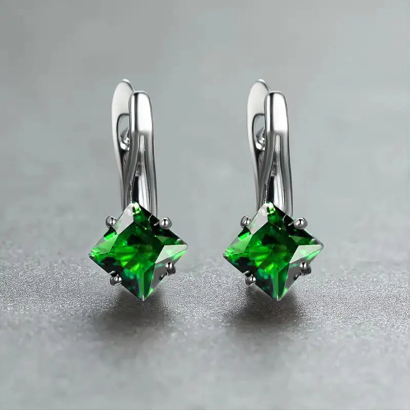 Women's copper earrings with diamond design and inlaid blue zircon stones on a white background.