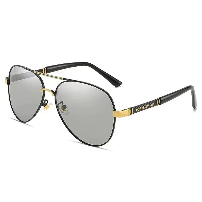 Men's gold metal frame polarised sunglasses with dragon and phoenix decoration and grey lenses on a table.