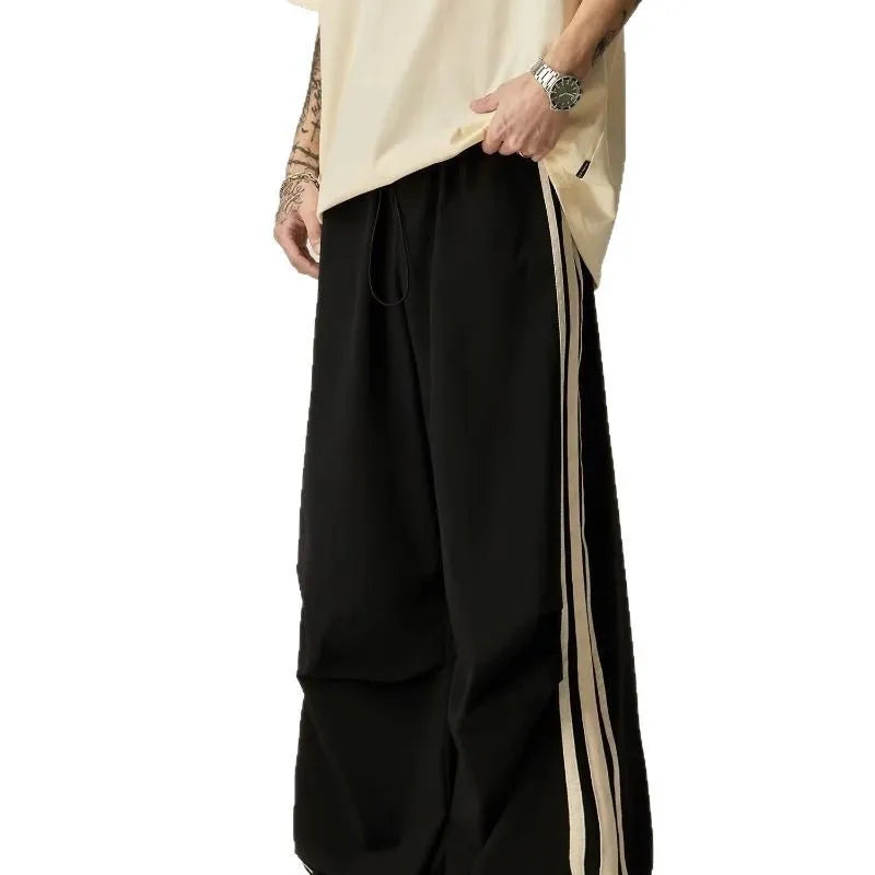 Black wide-leg men's climbing trousers with a high waist on a neutral background.