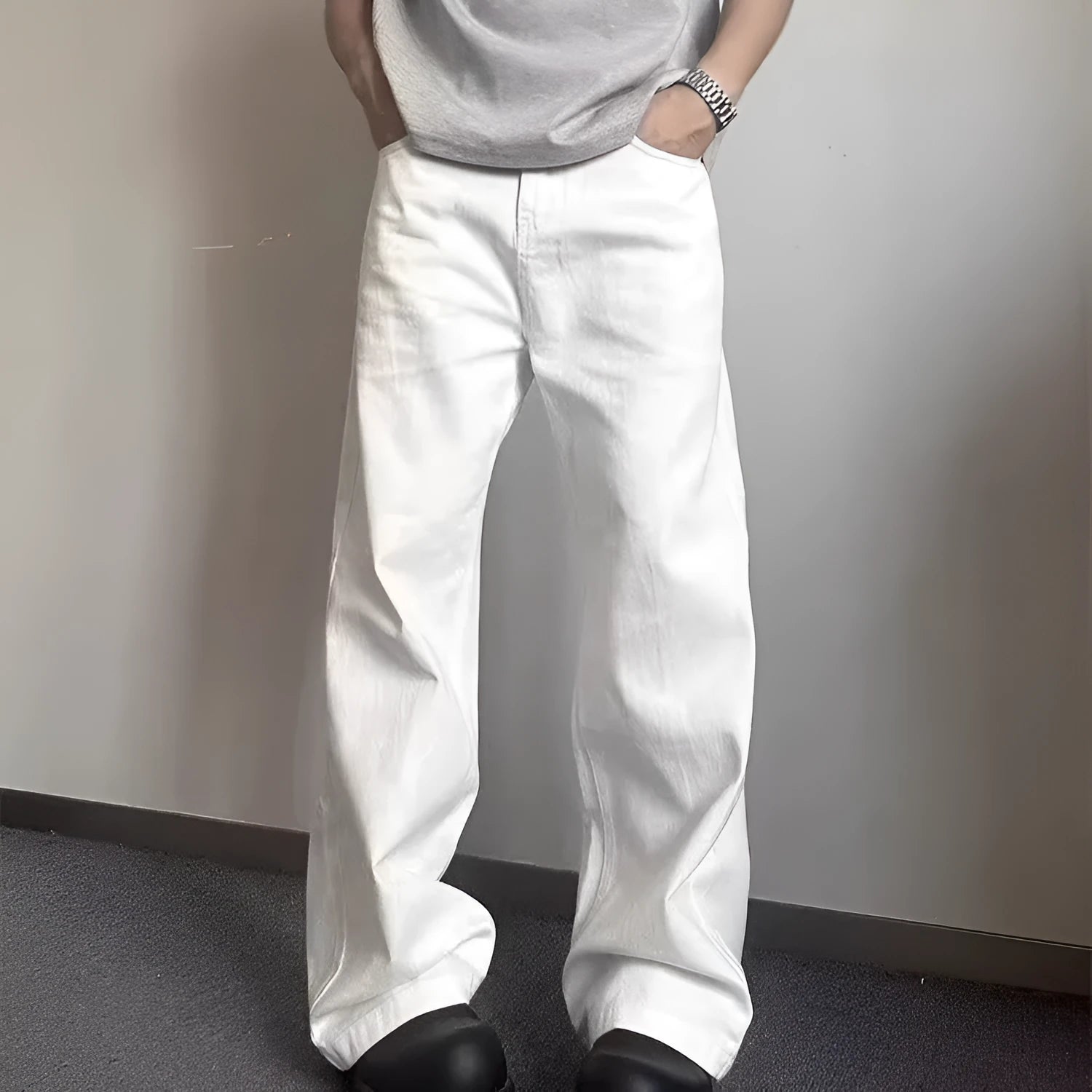 A pair of men's loose-fit white straight-leg cotton jeans on a plain background.