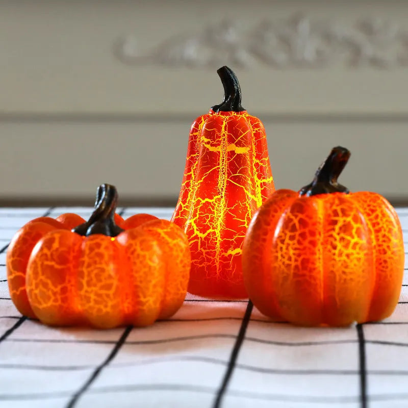 Three LED pumpkin lanterns in different sizes with realistic surface cracks and candle-like glow