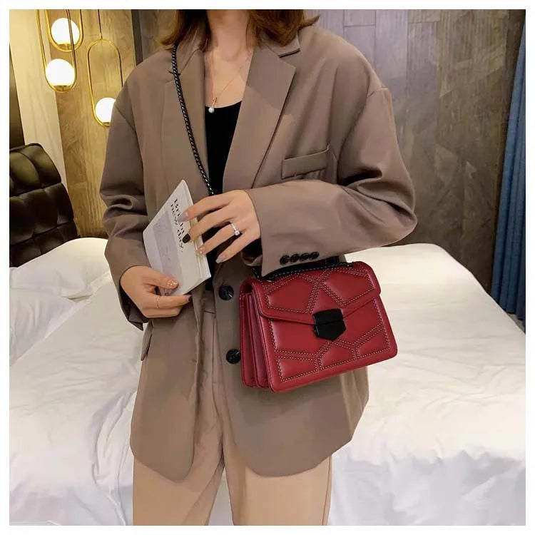 Small square shoulder bag with studs, chain handle, and zipper closure in wine red colour