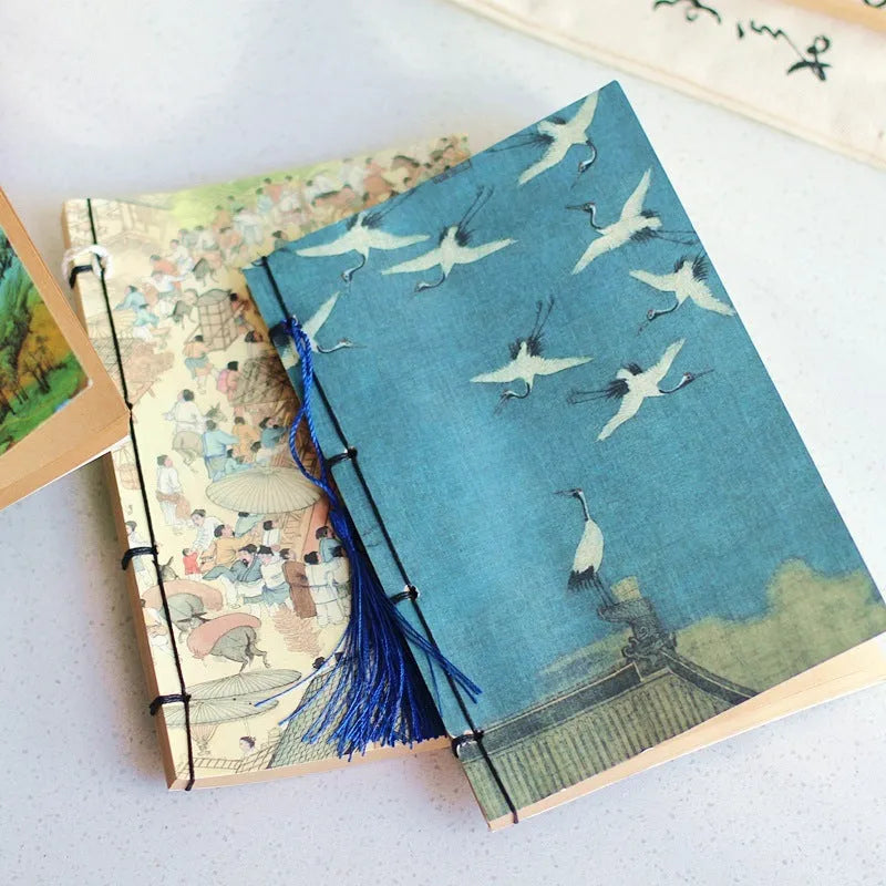 A5 antique wire-bound notebook with a retro famous painting cover on white cowhide, shown open on Kraft paper pages.