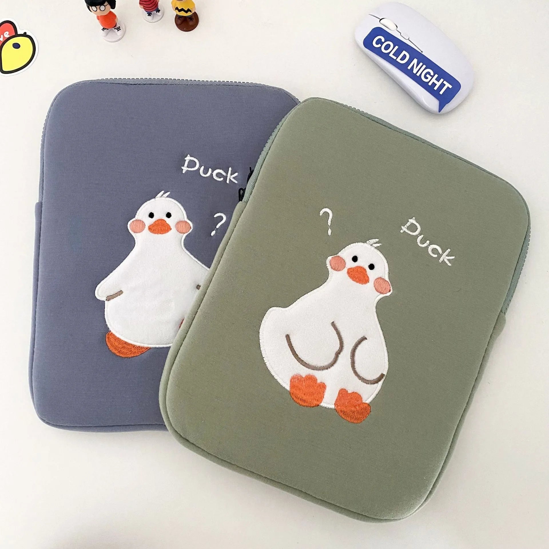 Blue tablet case with embroidered cartoon duck design and a silver zipper closure.