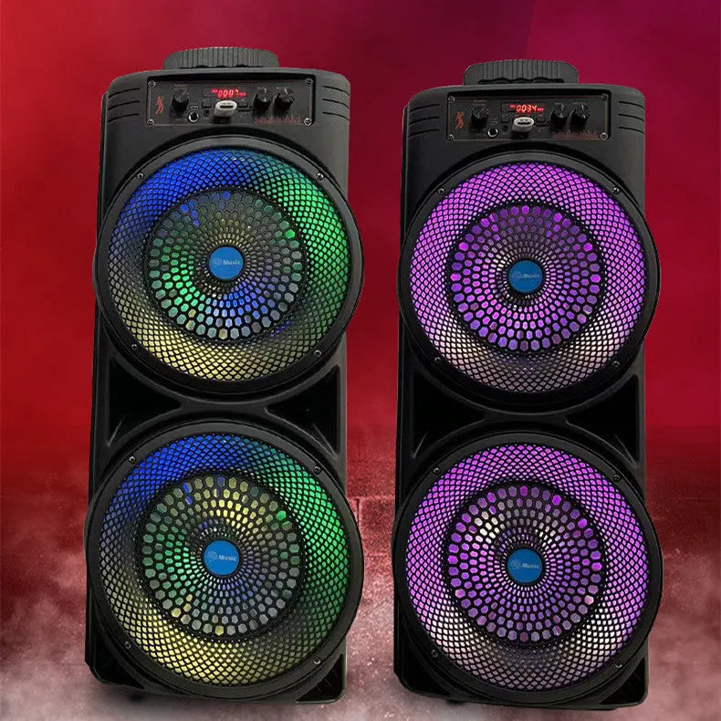 Black portable Bluetooth speaker with double 8-inch speakers, wired microphone, and remote control on a table