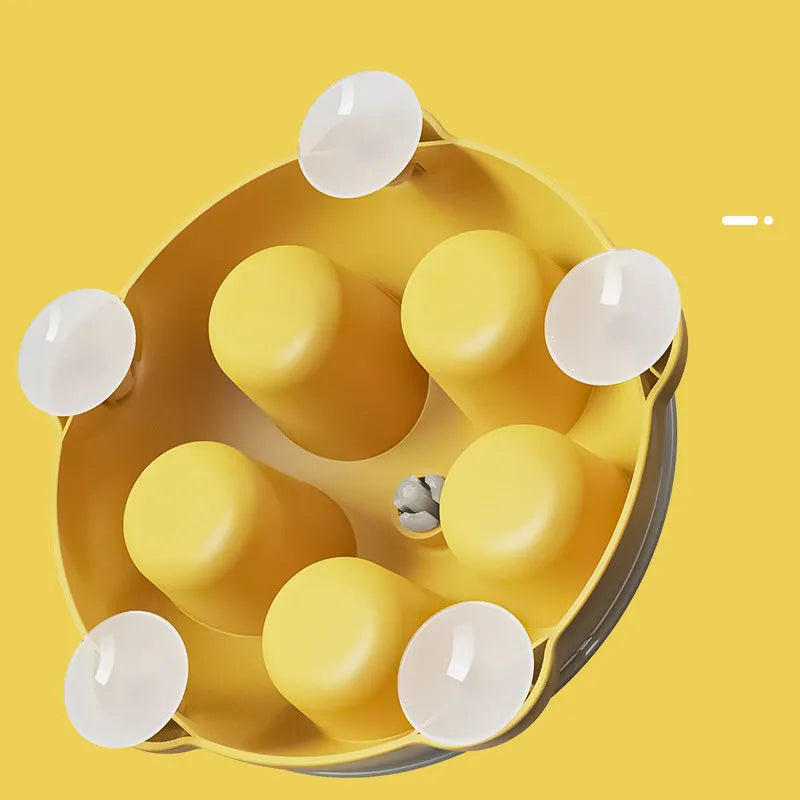Yellow interactive pet puzzle feeder bowl with ridges and treat compartments on a white background.