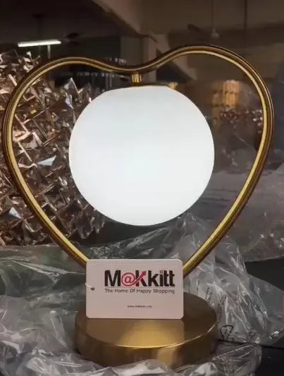 White heart-shaped decorative lamp with warm glow on a table.