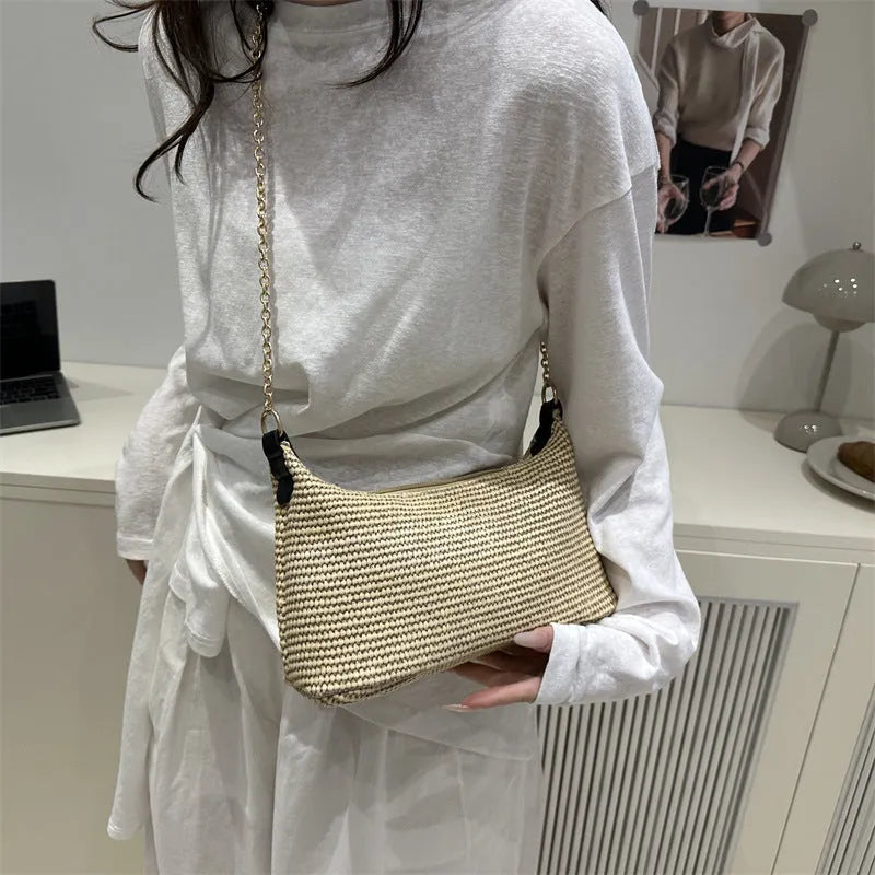 Woven straw beach shoulder tote bag in khaki colour with visible stitching and an outer pocket.