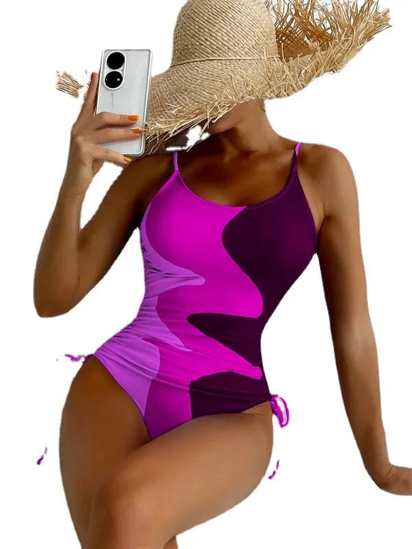 Women's blue sleeveless backless one-piece swimsuit with a striped print on a mannequin.