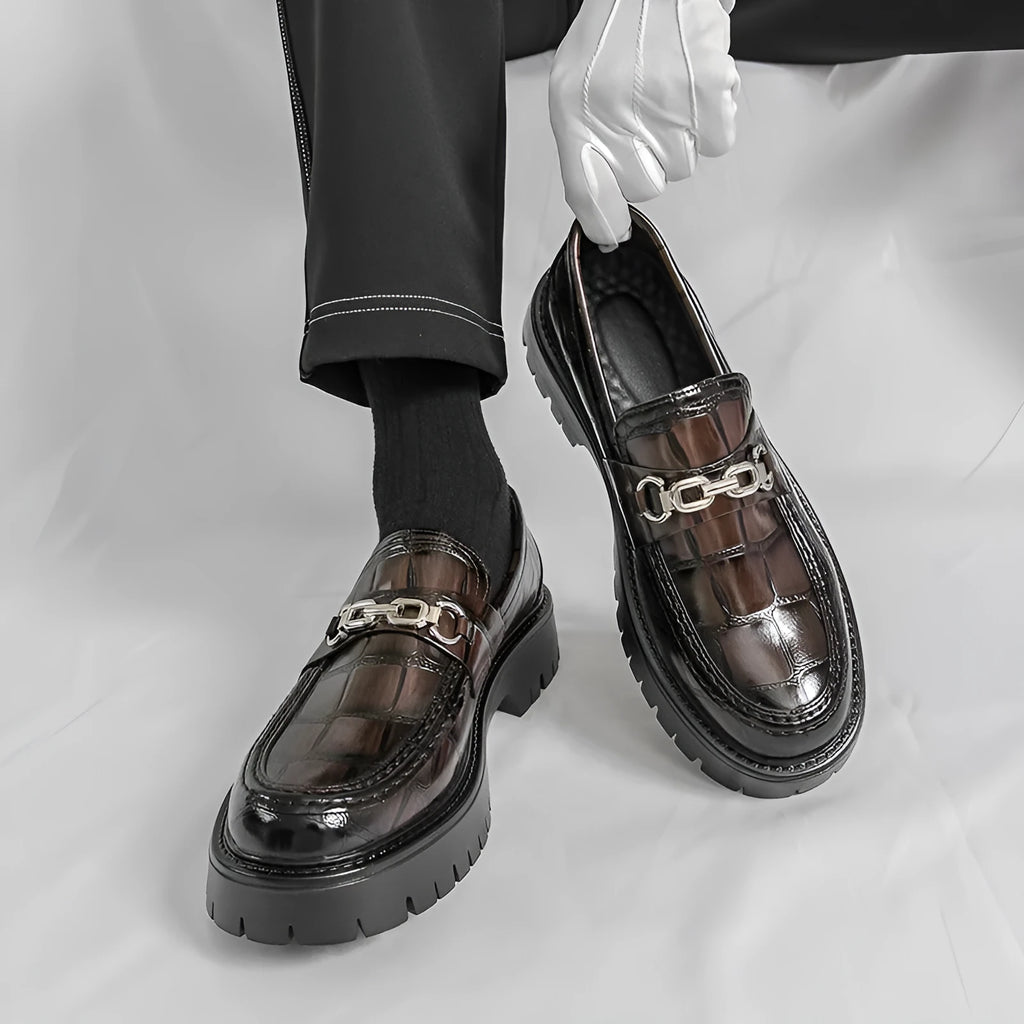 Men's black crocodile pattern leather loafers with a platform sole and flat heel.