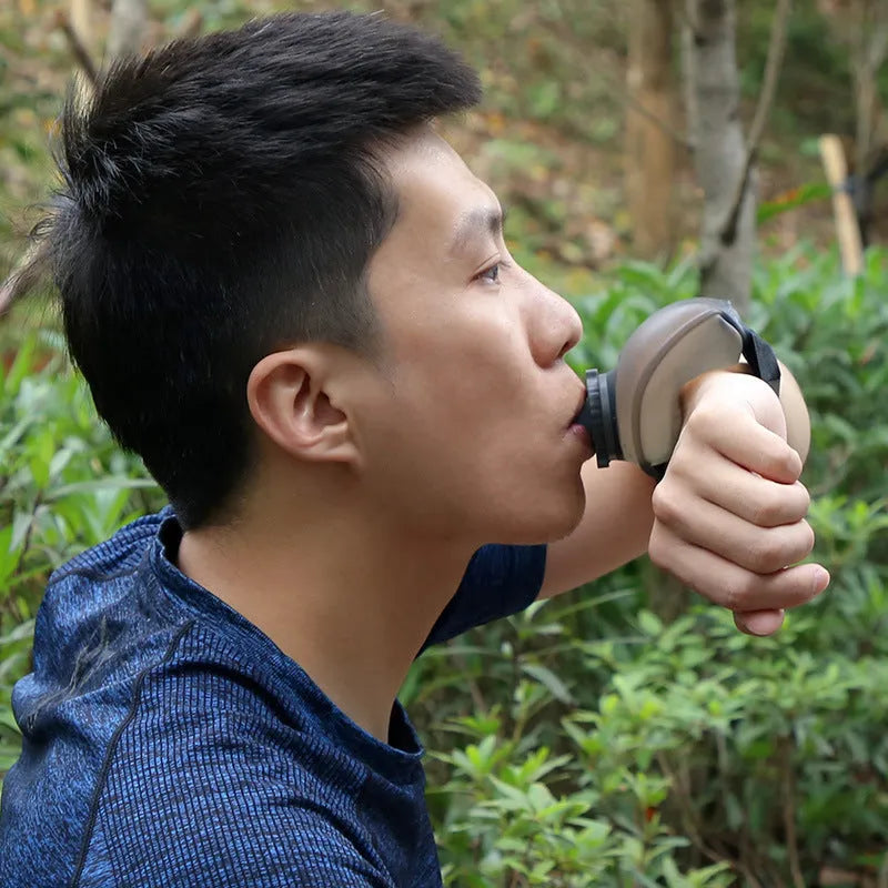 Orange wrist water bottle with Velcro strap and bite valve, shown mounted on wrist for running or cycling