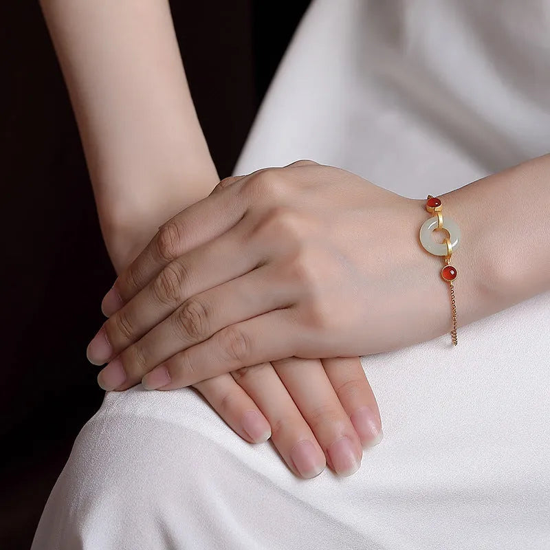 Gold plated S925 sterling silver bracelet with an inlaid natural Hetian jade peace buckle charm.