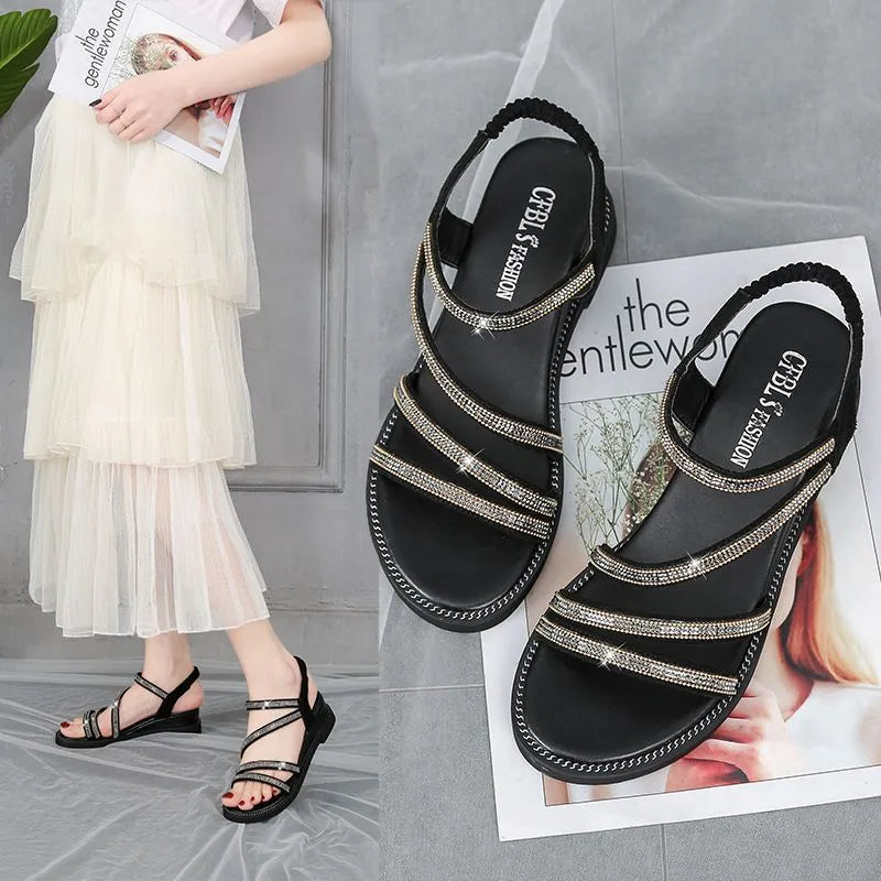Women's silver flat sandals with rhinestone details and a non-slip rubber sole.