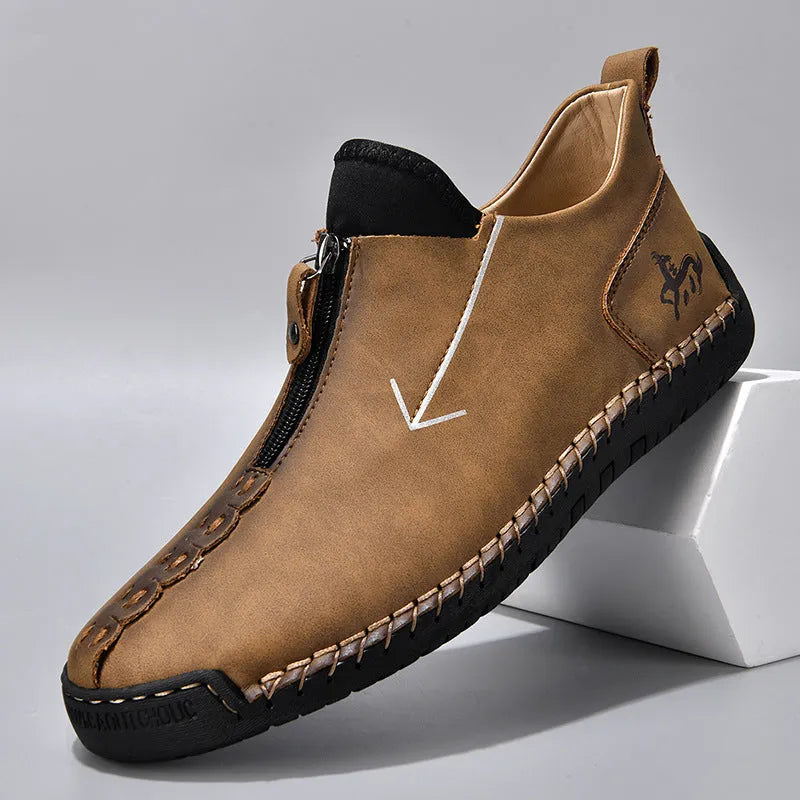 Men's black leather ankle boots with a front zipper and hand-stitched rubber sole.