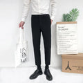 Man wearing black straight-leg cotton trousers with a drawstring waist, styled casually.