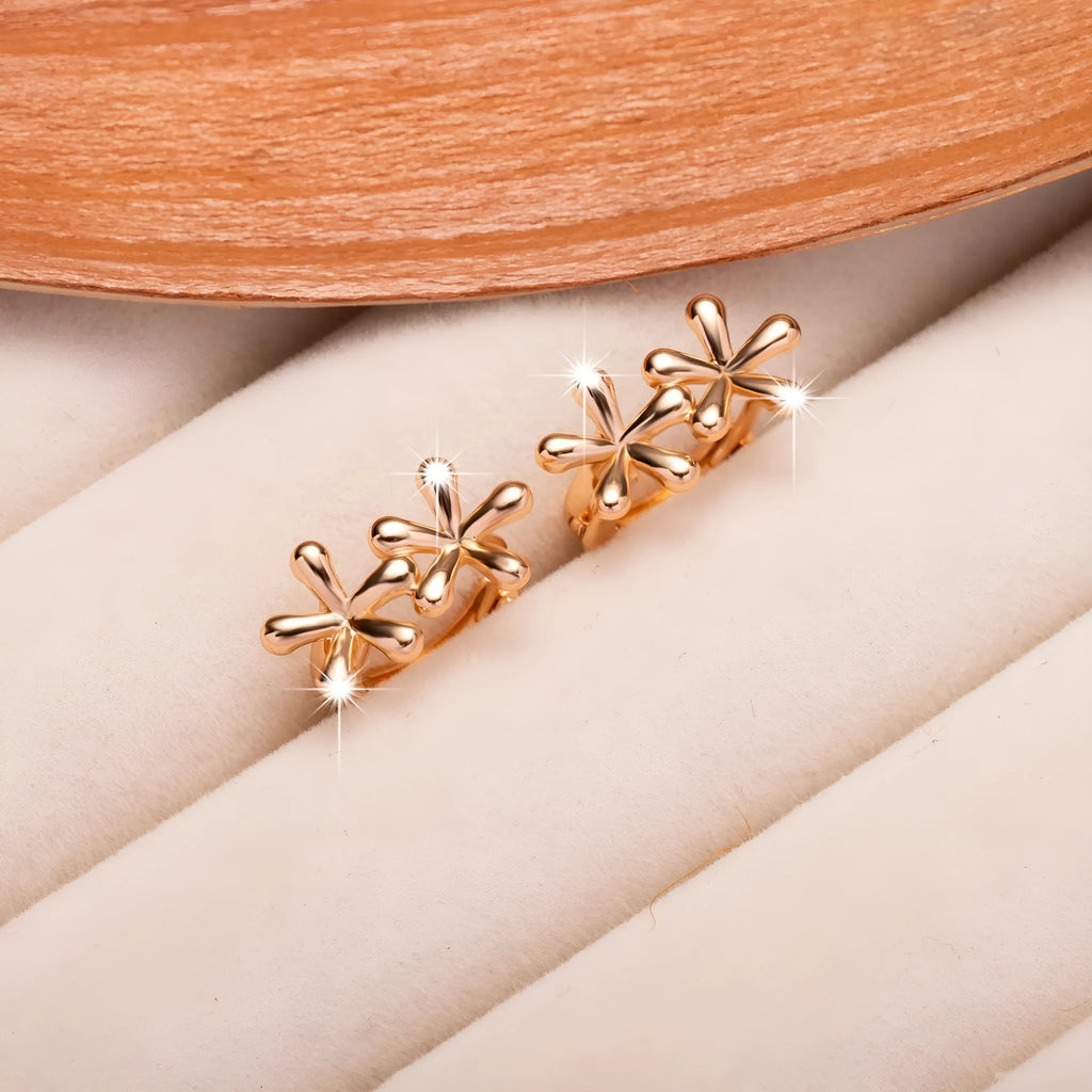 Rose gold electroplated earrings with a waterdrop shape and detailed floral petal etching on a white background.