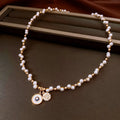 Gold electroplated round pendant necklace with zircon accents on clavicle chain