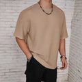 Man wearing a loose-fit light blue hollow solid colour men's t-shirt with short sleeves.