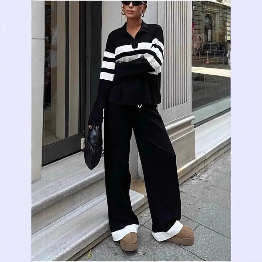 Women's black and white striped knitted polo shirt with long sleeves paired with matching trousers.