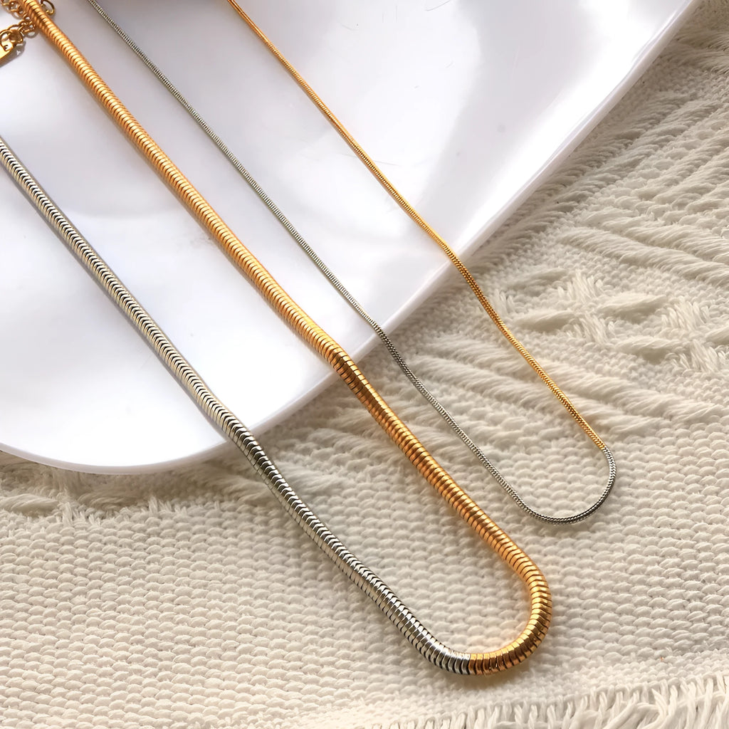 Gold-coloured stainless steel snake bones chain necklace with 3mm wide geometric links.