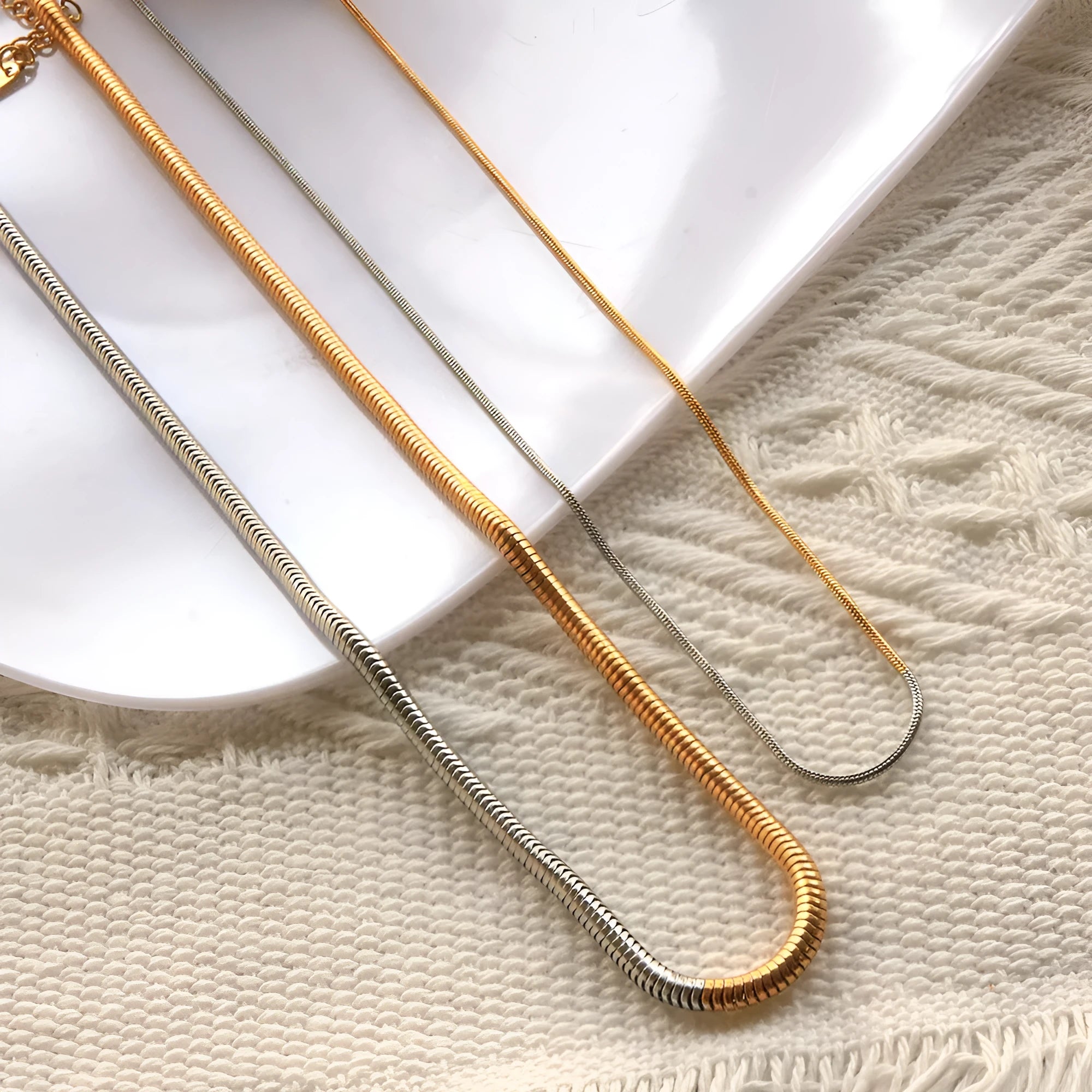Gold-coloured stainless steel snake bones chain necklace with 3mm wide geometric links.