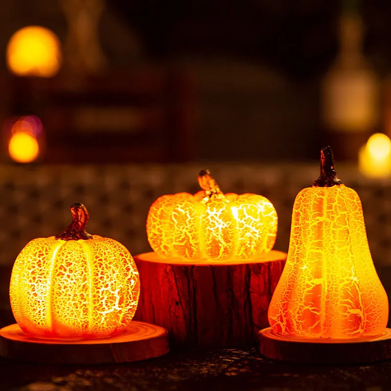 Three LED pumpkin lanterns in different sizes with realistic surface cracks and candle-like glow
