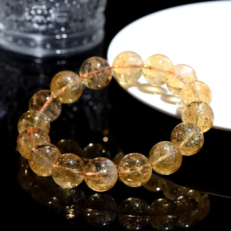 Natural yellow citrine gemstone bead bracelet on a wrist, showing geometric beads.