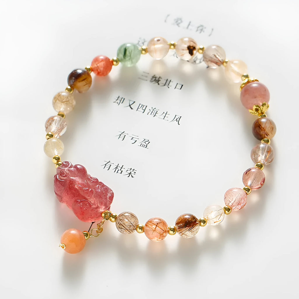Natural strawberry quartz and copper bracelet with pearl accents on a wrist.