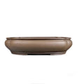 Handmade antique papaya-shaped purple clay flower pot on a wooden surface.